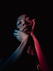 A warm, cinematic portrait of a focused young adult studying with deep blue and cream tones in the background.