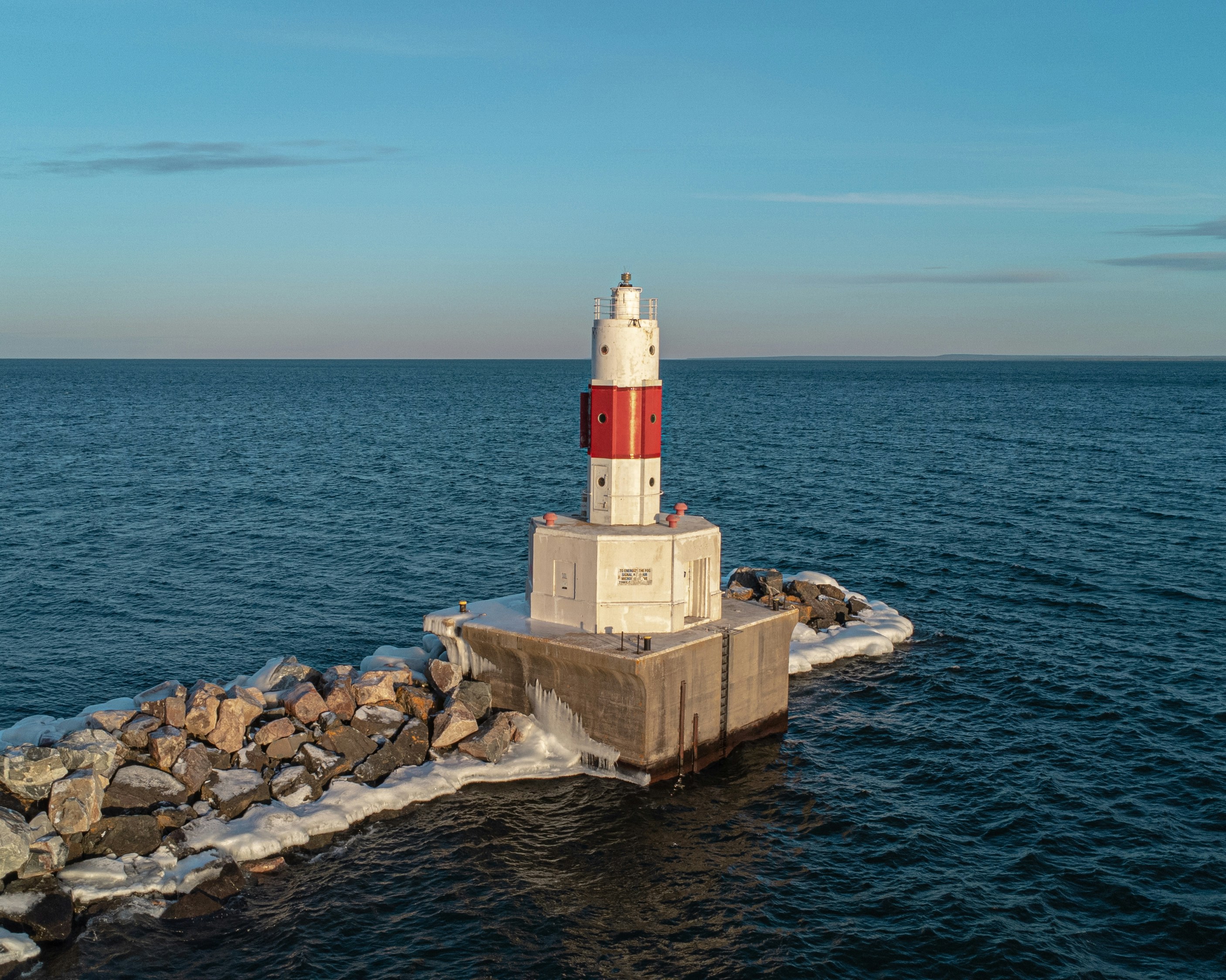 A red and white lighthouse sitting on top of a pier photo – Free Winter ...