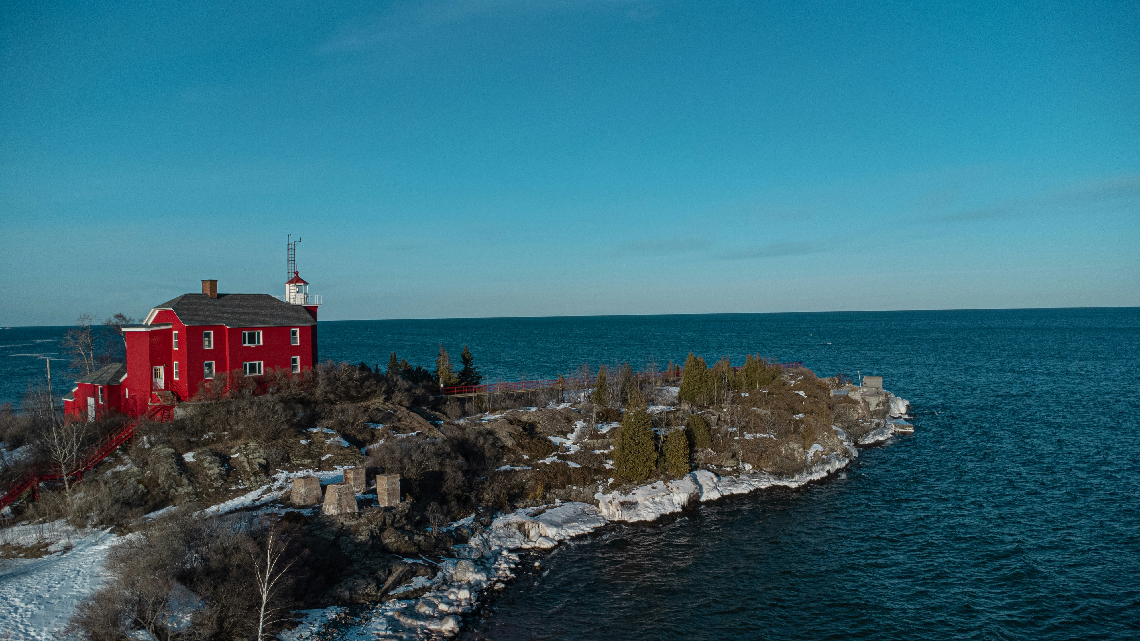 a red house on an island in the middle of the ocean