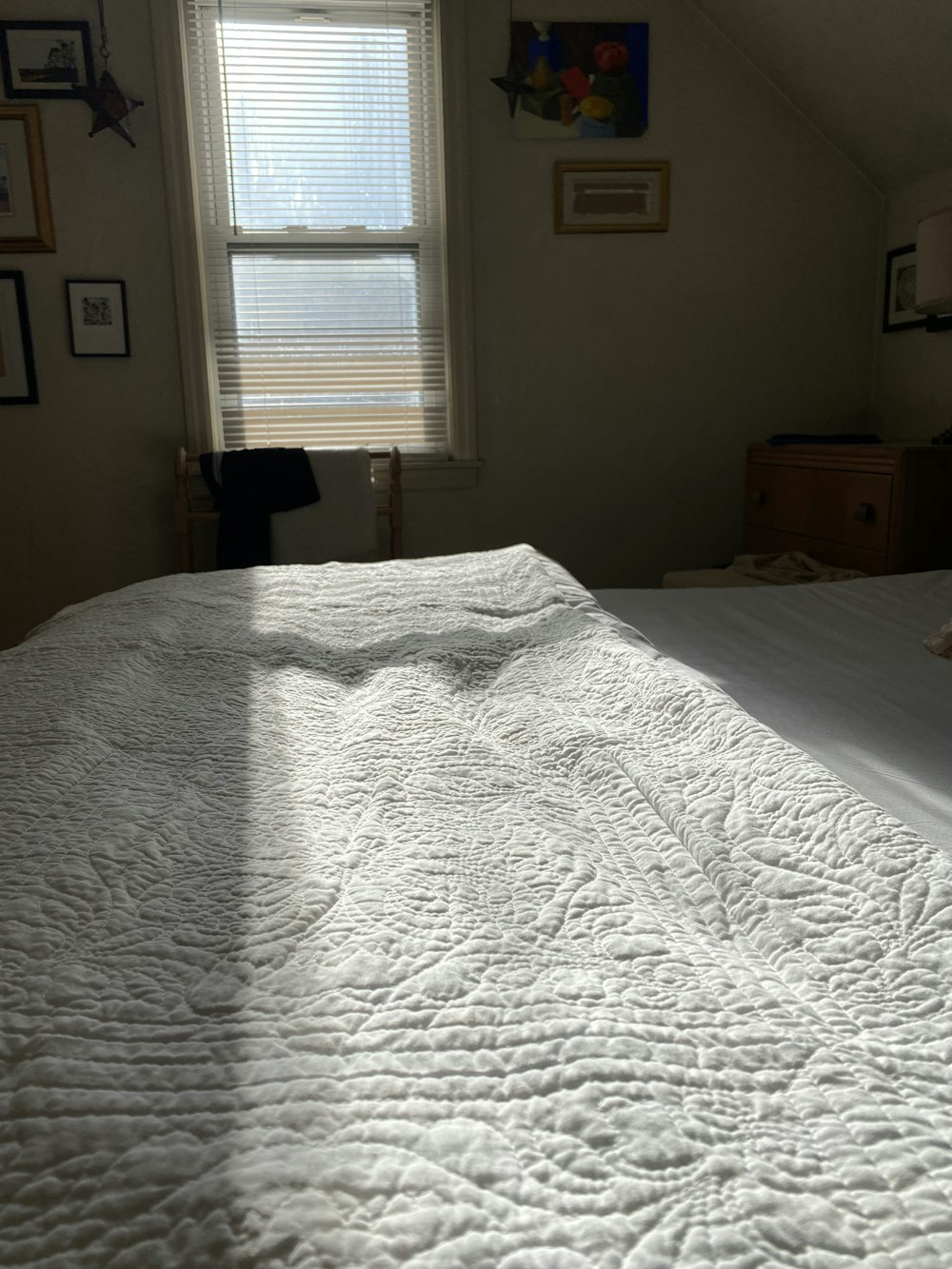 a bed with a white bedspread and a window