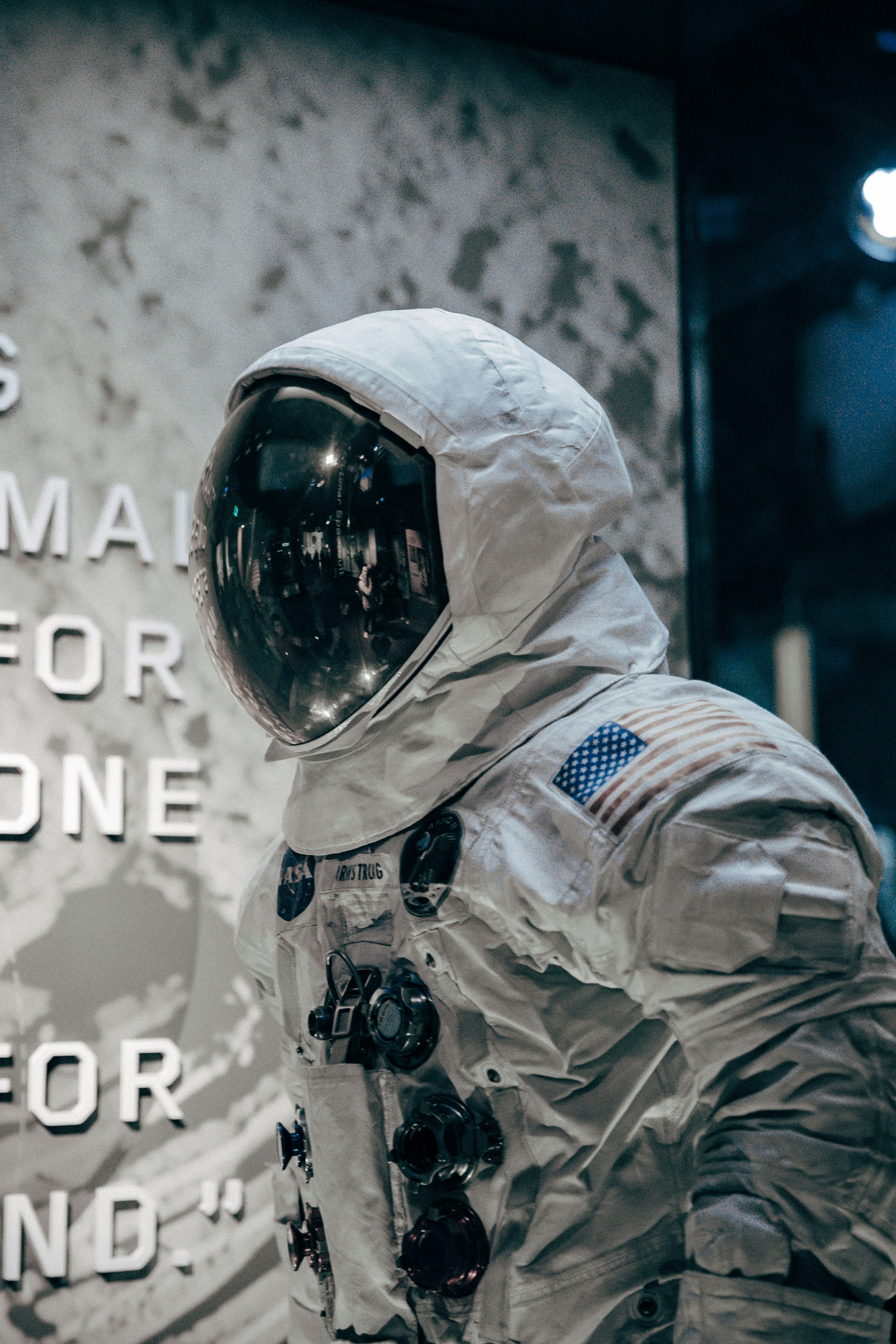 Tuta spaziale di astronauta con patch NASA esposta in una galleria museale.