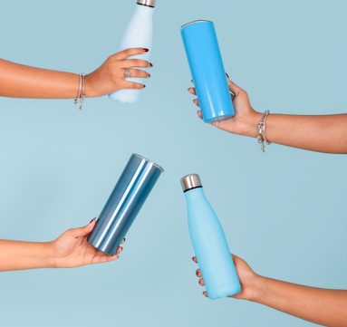 a group of people holding different colored water bottles