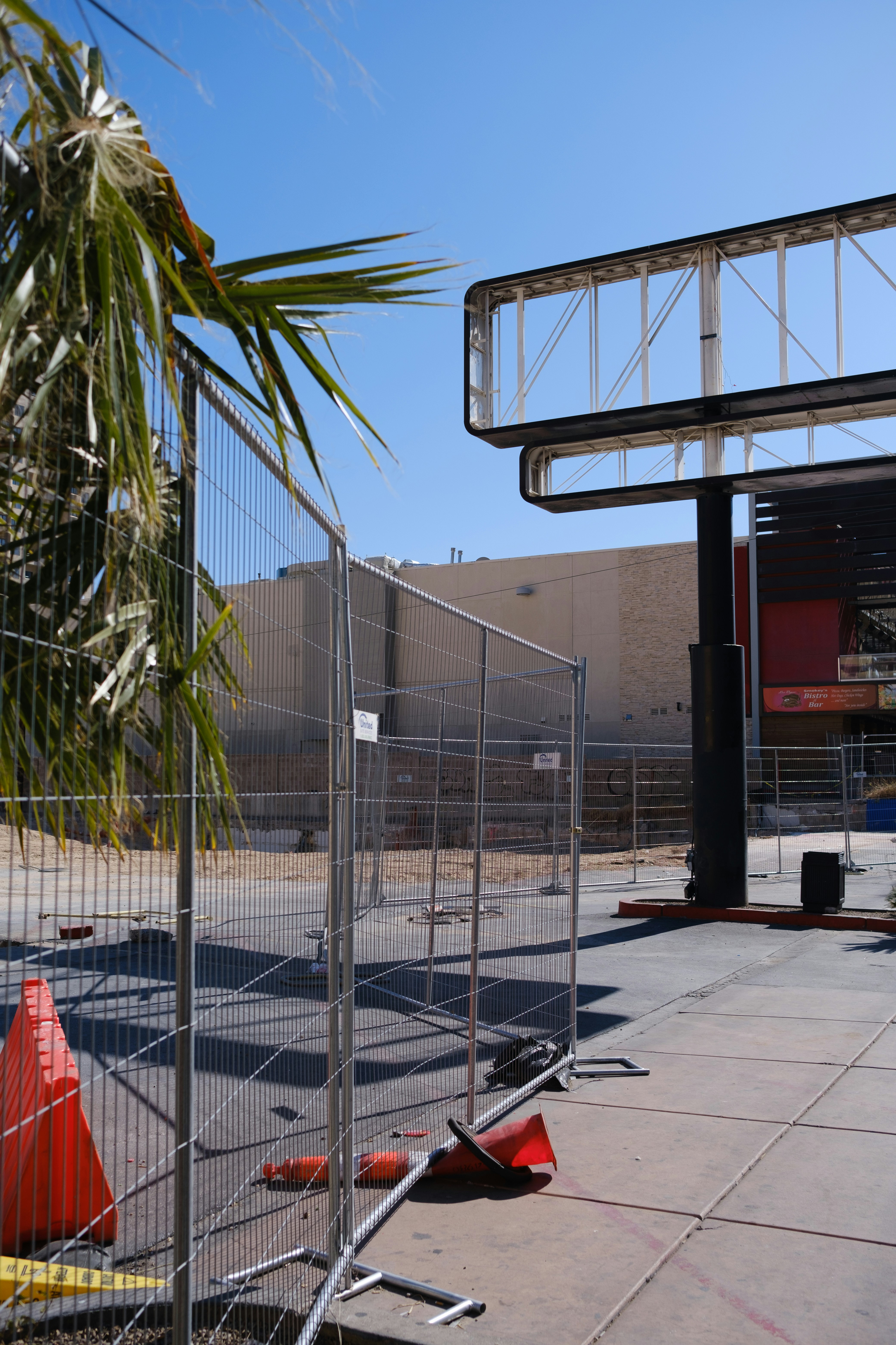 a fenced off parking lot with a palm tree