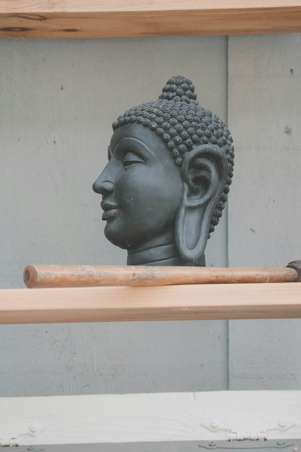 Une statue d’un Bouddha avec un bâton de bois