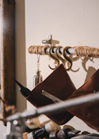 Close-up of jali hooks mounted on a wall, holding various tools and items neatly.