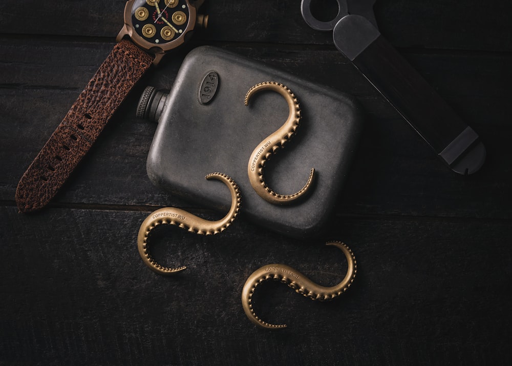 A watch and some gold octopus tentacles on a black surface photo