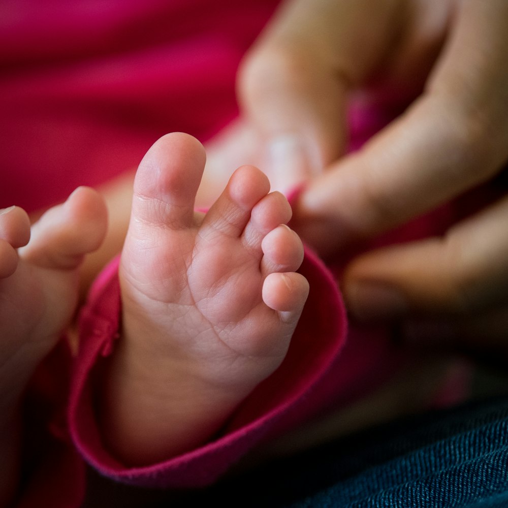 a close up of a person holding a baby's foot
