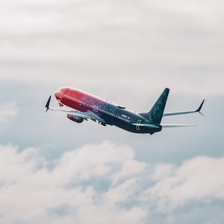 A commercial airplane with 'More to Love' written on the fuselage ascends through a cloudy sky, showcasing a gradient color scheme from red to purple.