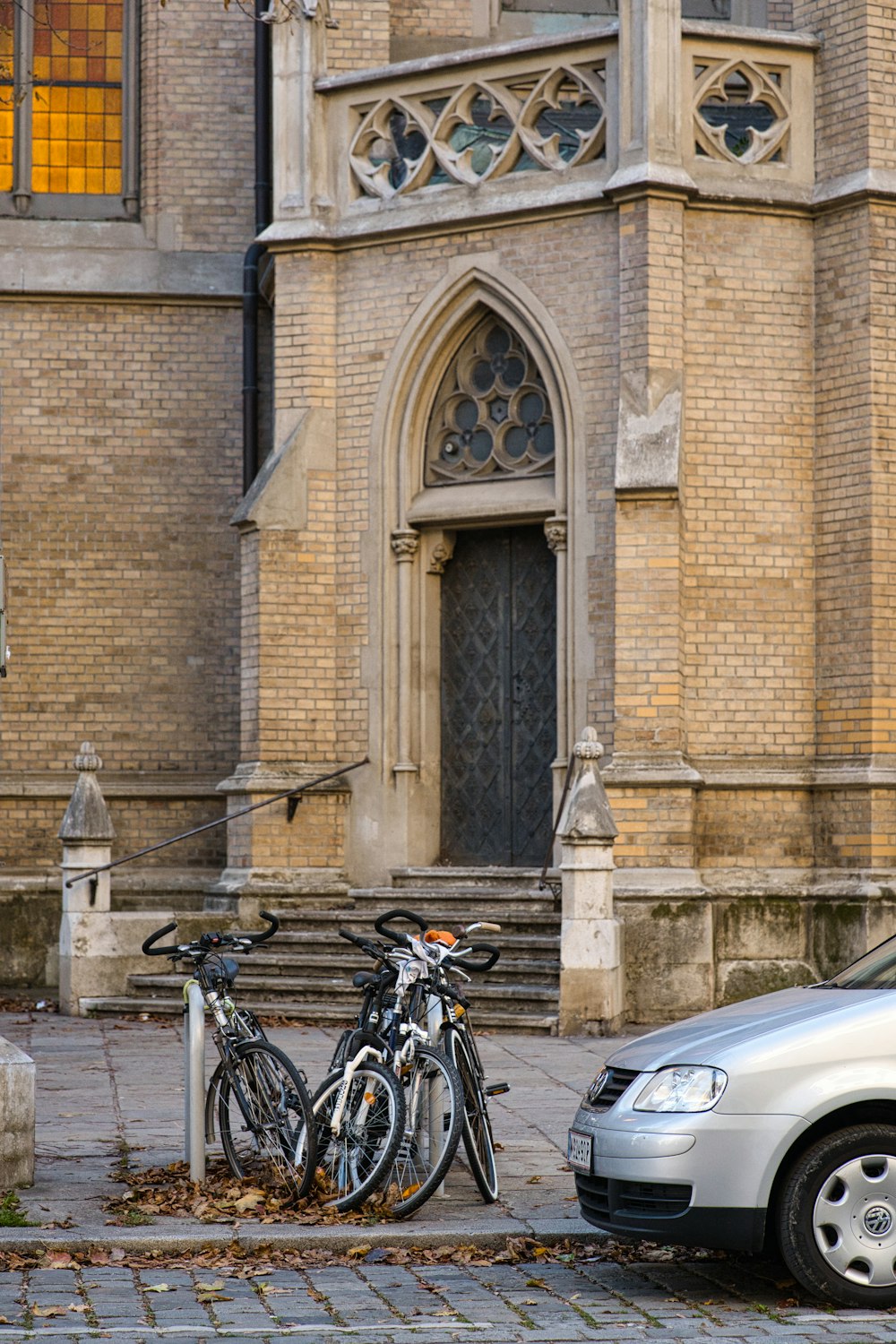 a silver car parked in front of a tall building