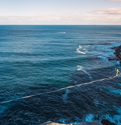 a rope is attached to the edge of a cliff near the ocean