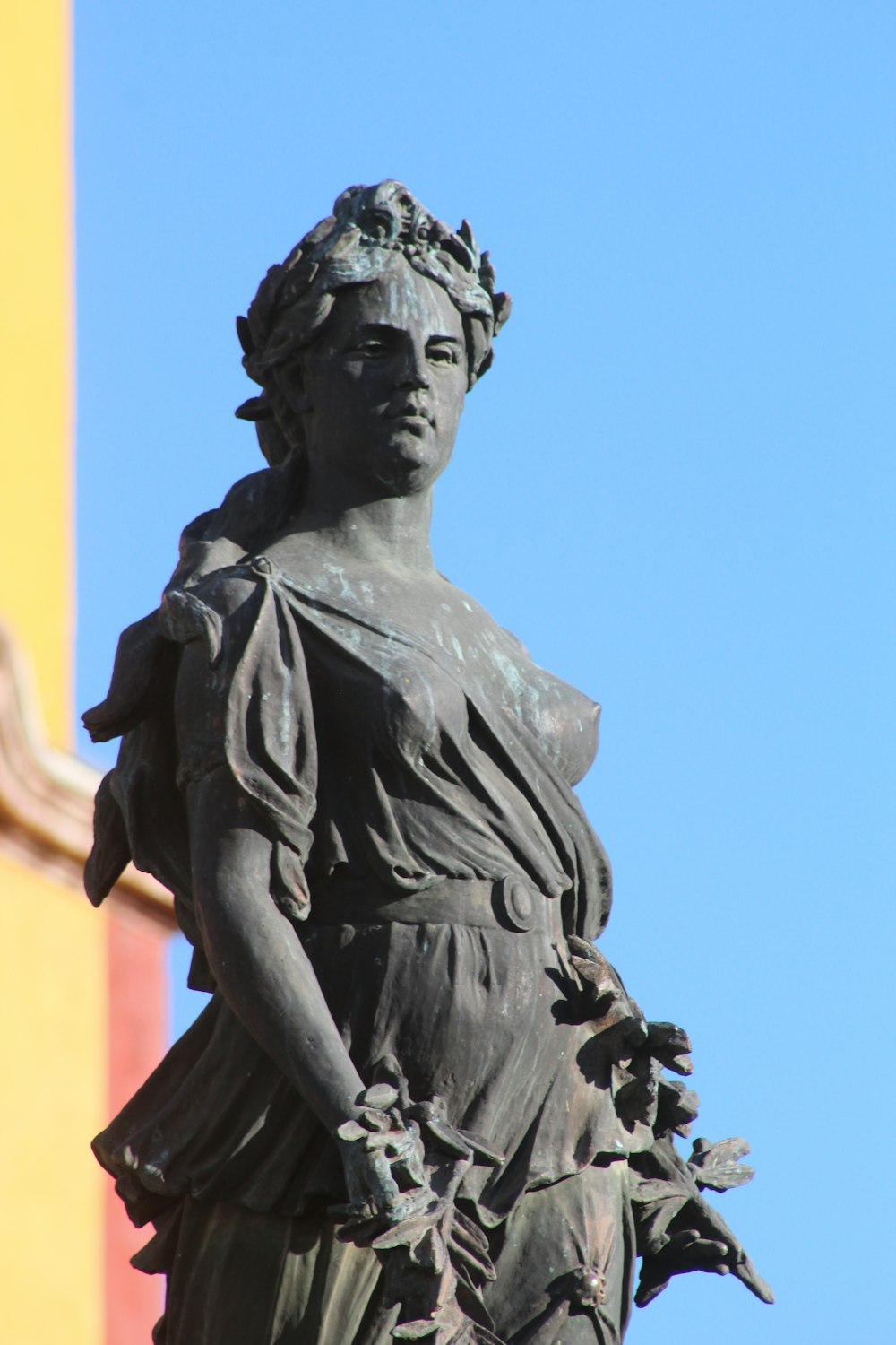 a statue of a woman holding a bird on top of a building