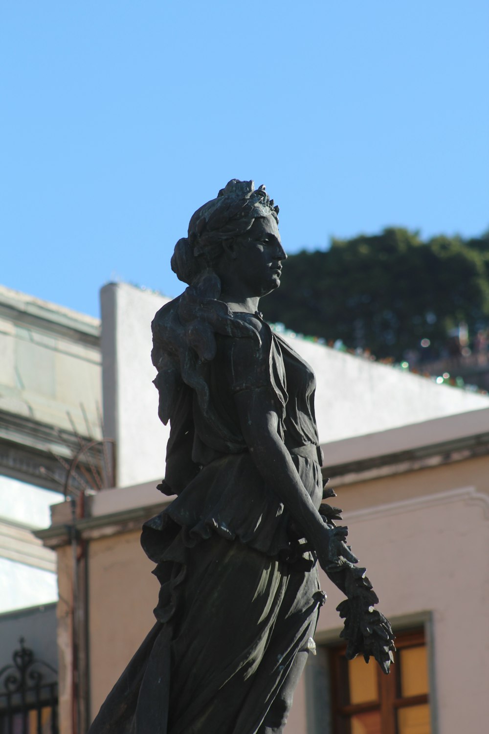 a statue of a woman holding a flower in her hand