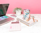 A peaceful desk setup with a planner, pen, and a small succulent in soft beige tones.
