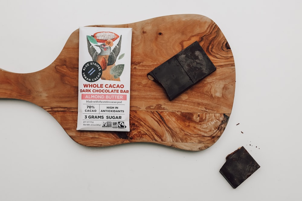 a wooden cutting board with a bar of black soap on top of it