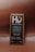 A chocolate bar wrapped in brown packaging with a focus on a square label featuring the brand name Hu and the message 'Get Back to Human.' The product is labeled as Vanilla Crunch Dark Chocolate with 70% organic cacao, vegan, primal, and free from refined sugars, dairy, soy, and other additives.