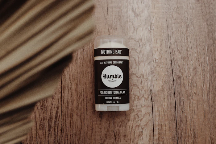 Bottle of natural deodorant on a wooden bathroom shelf