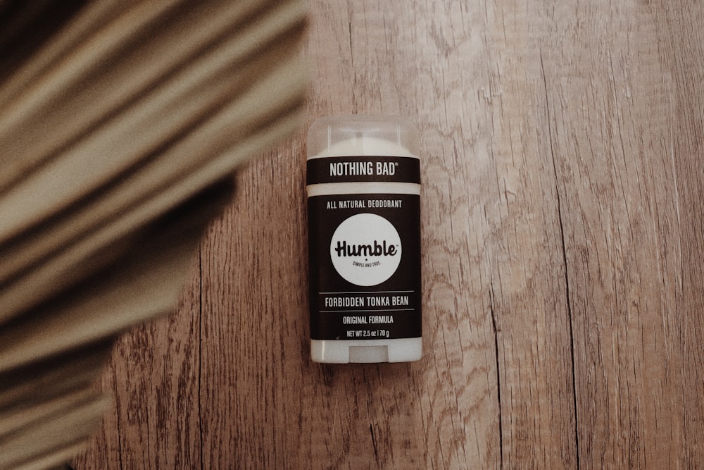 a close up of a bottle of deodorant on a wooden surface