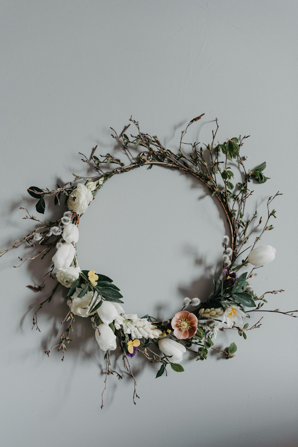 a wreath made of branches and flowers on a wall