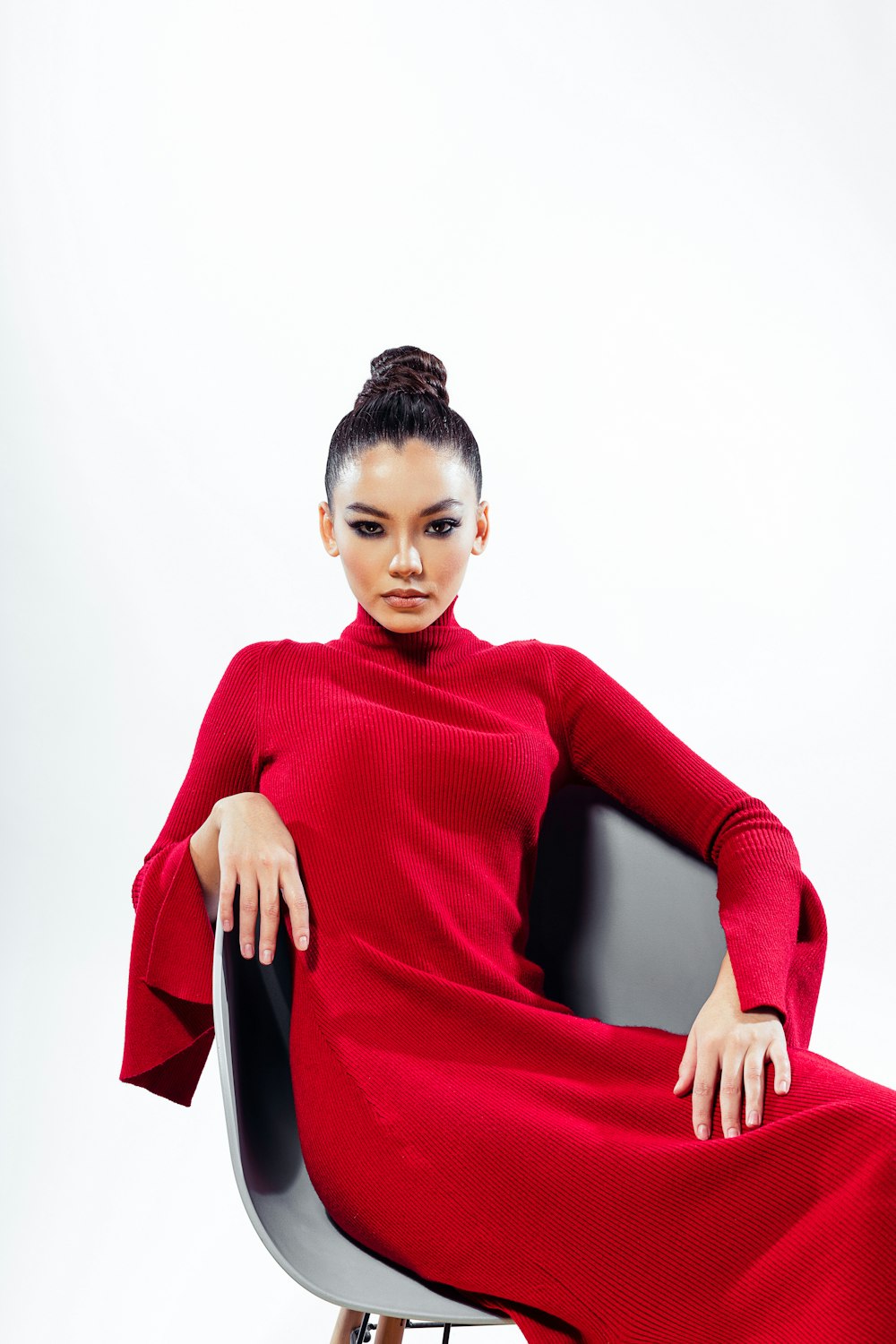 a woman in a red dress sitting on a chair