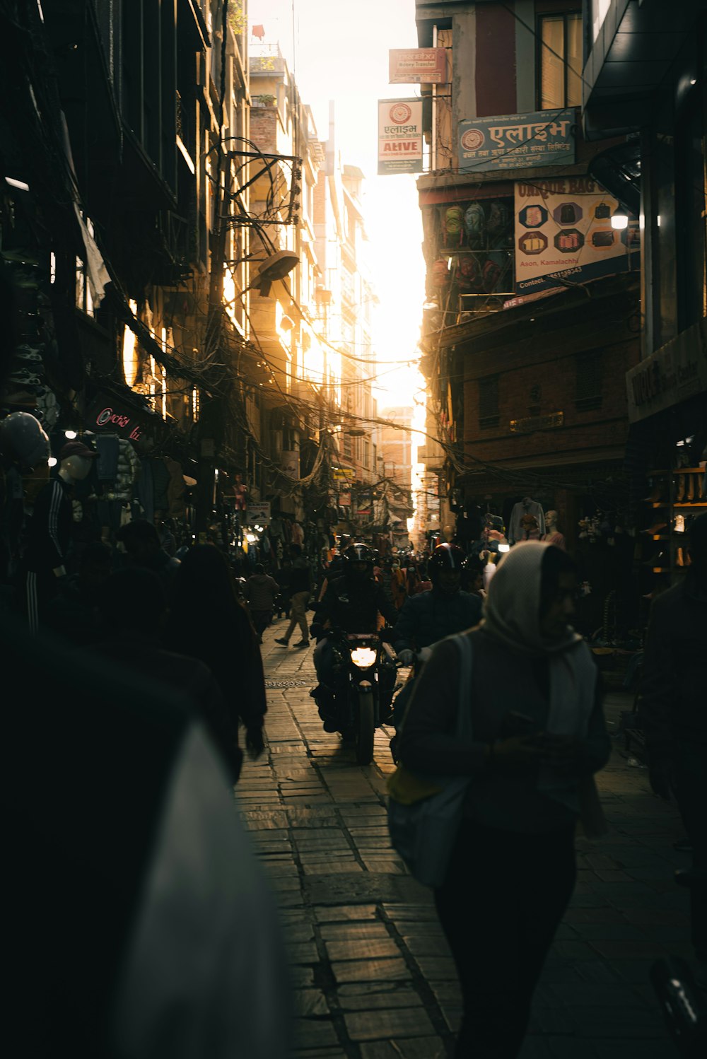 a group of people walking down a street next to tall buildings