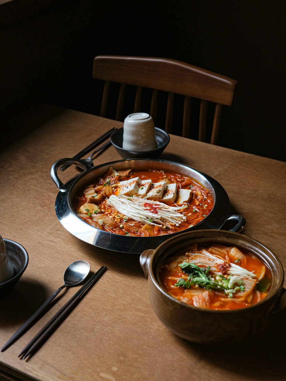 a wooden table topped with bowls of food