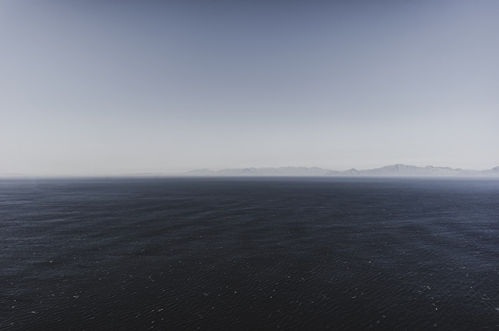 a large body of water with mountains in the distance