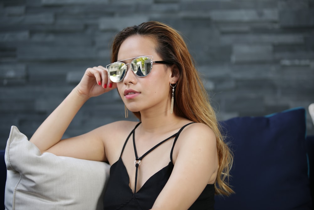 a woman sitting on a couch wearing sunglasses