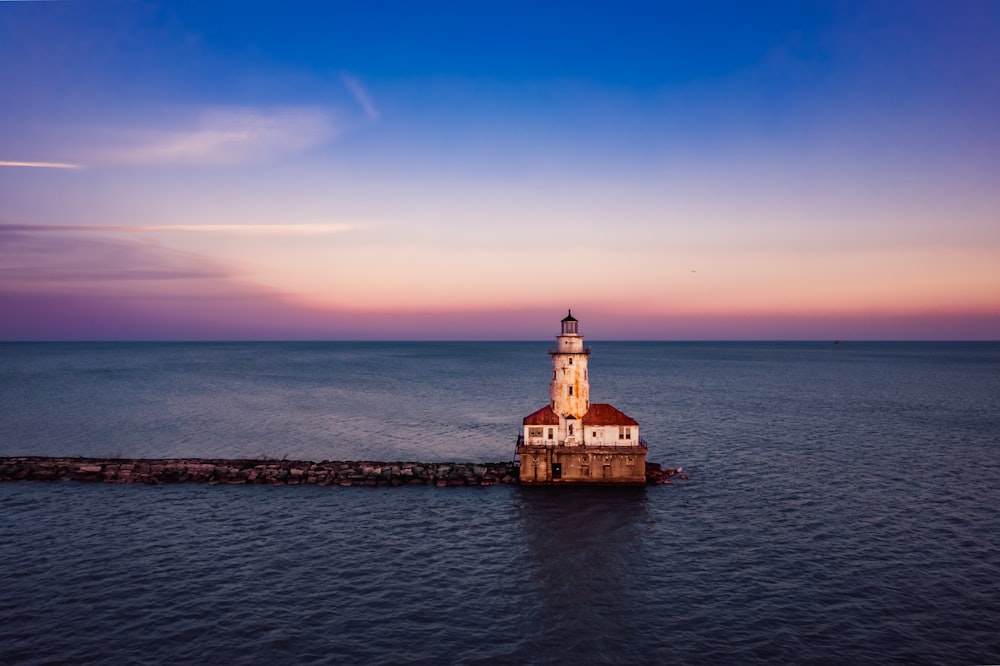 a light house sitting on top of a pier next to the ocean