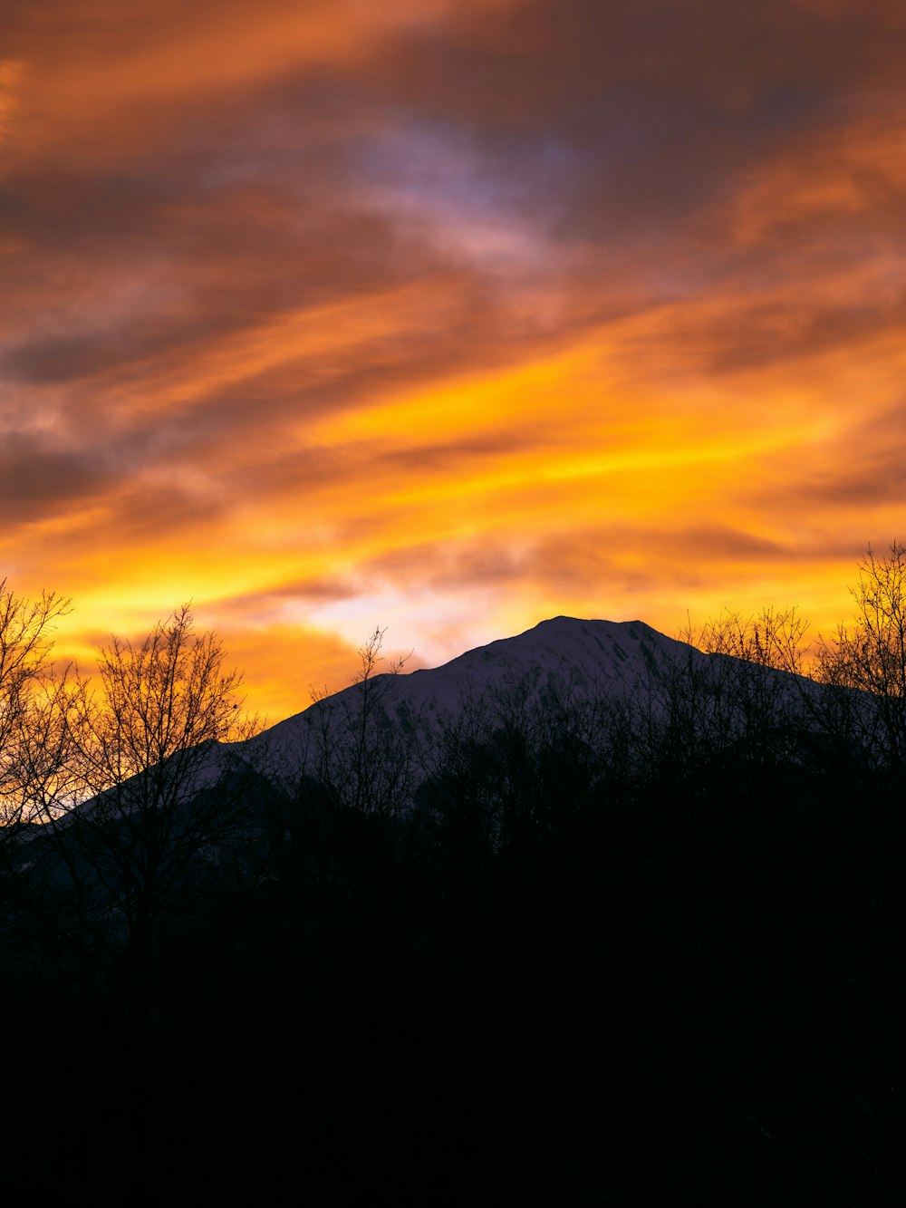 a sunset with a mountain in the background