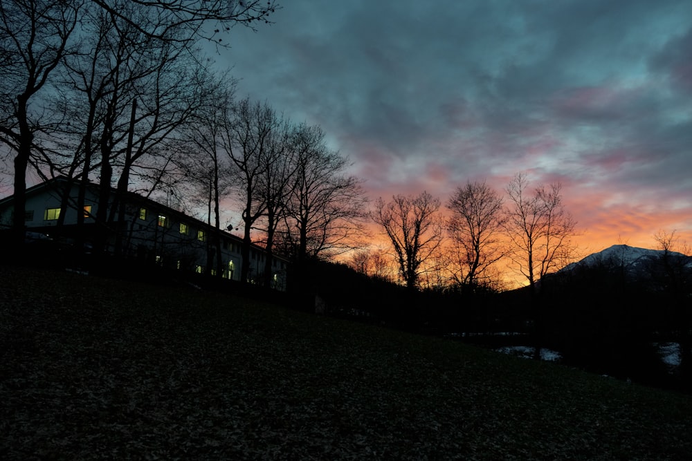 a house sitting on top of a hill under a cloudy sky