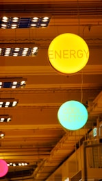 a group of neon signs hanging from the ceiling of a building