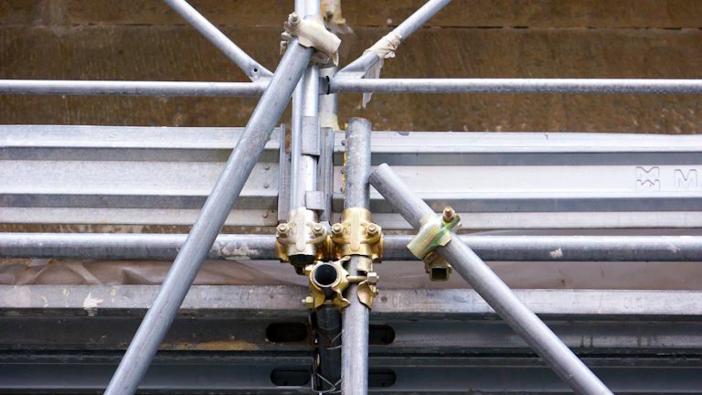 Close-up of sturdy metal scaffolding joints at a construction site.