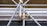 A close-up view of a complex structure made of interlocking metal scaffolding tubes and clamps. The metal is predominantly silver and grey with hints of golden brass at the joints. The scaffolding appears sturdy and is likely used in construction or maintenance work.