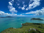 A panoramic view of the turquoise waters surrounding the lush green islands under a clear blue sky.