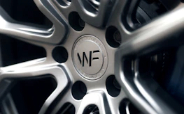 Detailed shot of the floating center logo on a spinning Velaris rim, highlighting precision engineering.