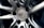A close-up view of a polished metal car wheel hub with intricate design patterns. The central area features a circular logo with letters and text indicating manufacturing details. The surfaces are smooth and reflective, highlighting the craftsmanship of the metalwork.
