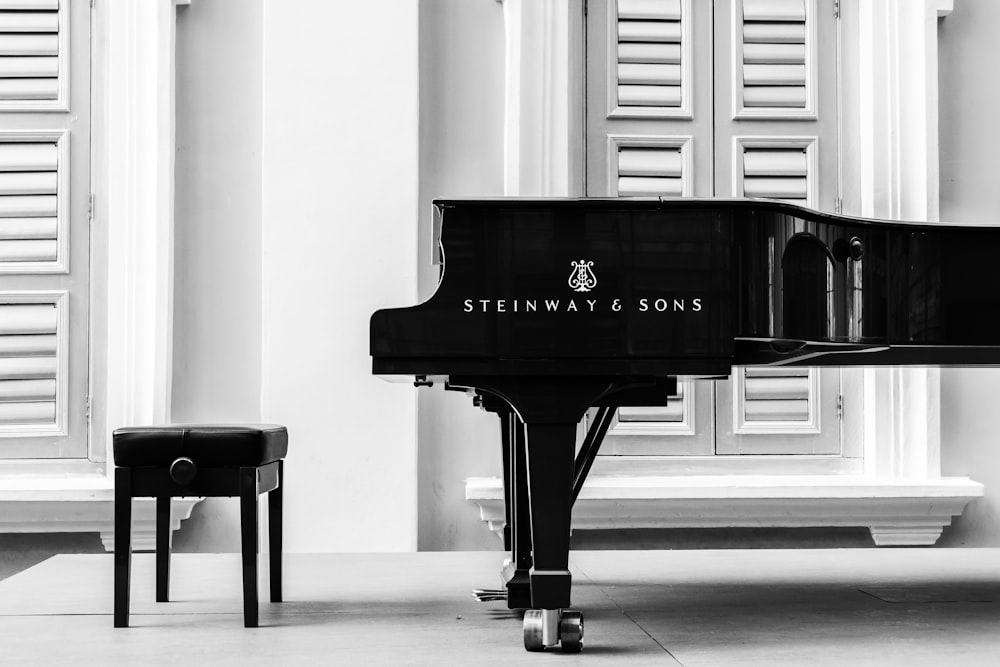 a black piano sitting in front of a window