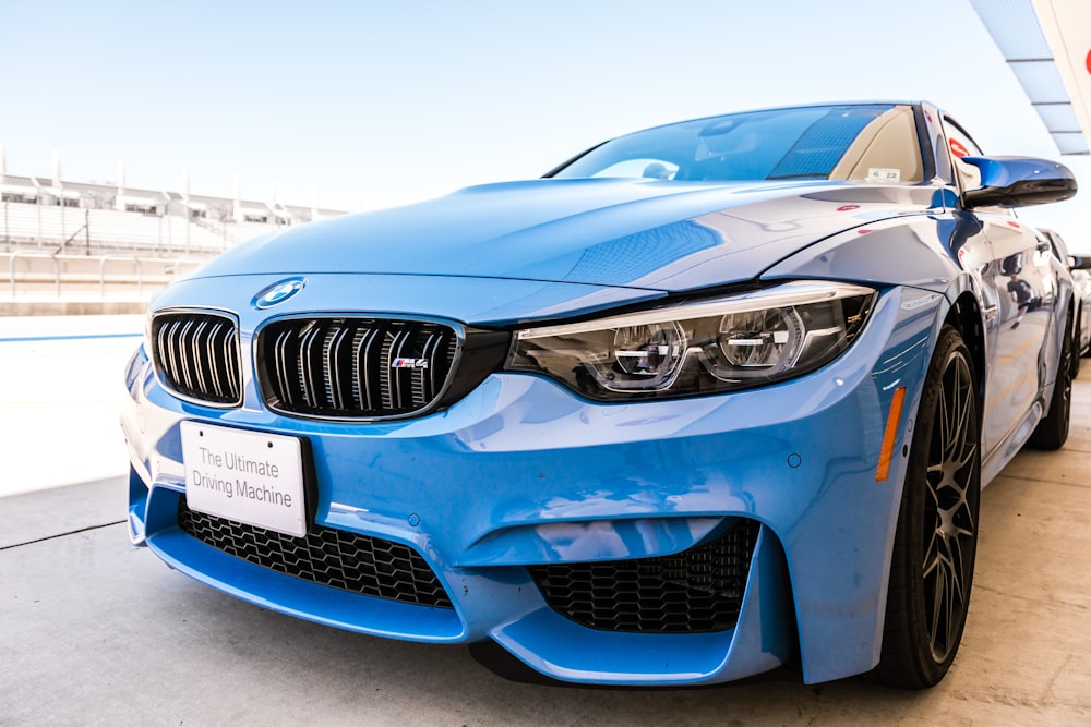 Une voiture BMW bleue garée dans un parking