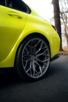 Dynamic shot of a car wheel with a bright yellow PKL centre cap spinning on the road.