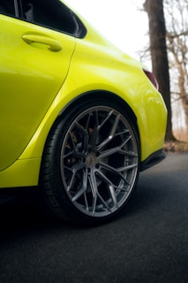 Dynamic shot of a car wheel with a bright yellow PKL centre cap spinning on the road.