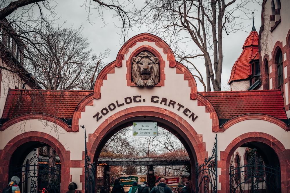 a group of people standing outside of a zoo