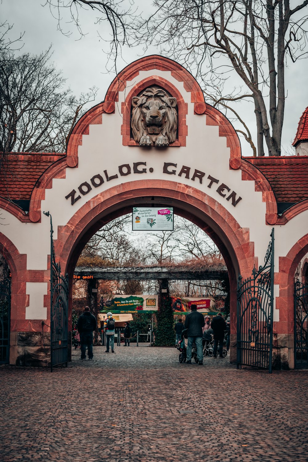 a zoo entrance with a lion head on it