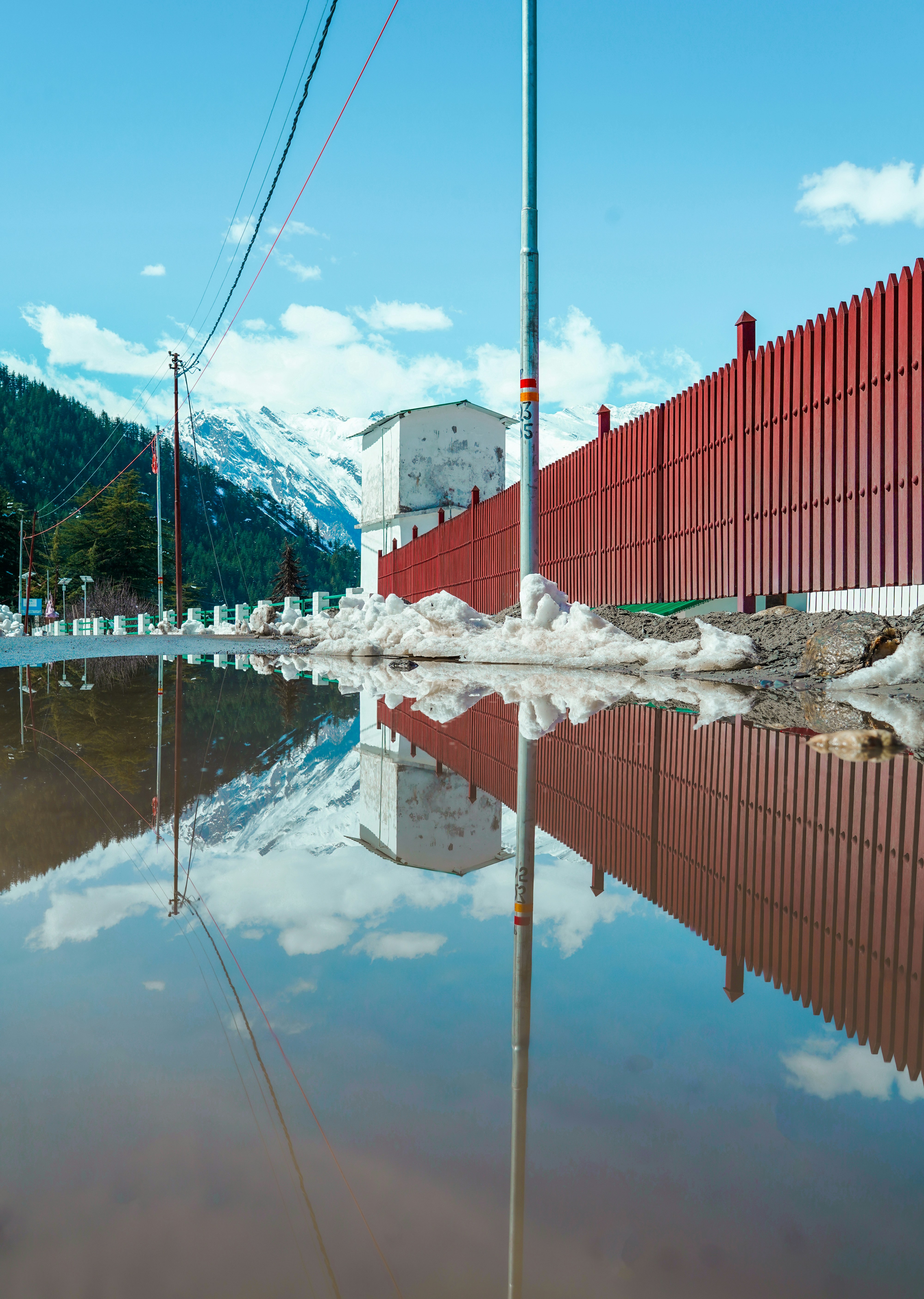 a red fence sitting next to a body of water