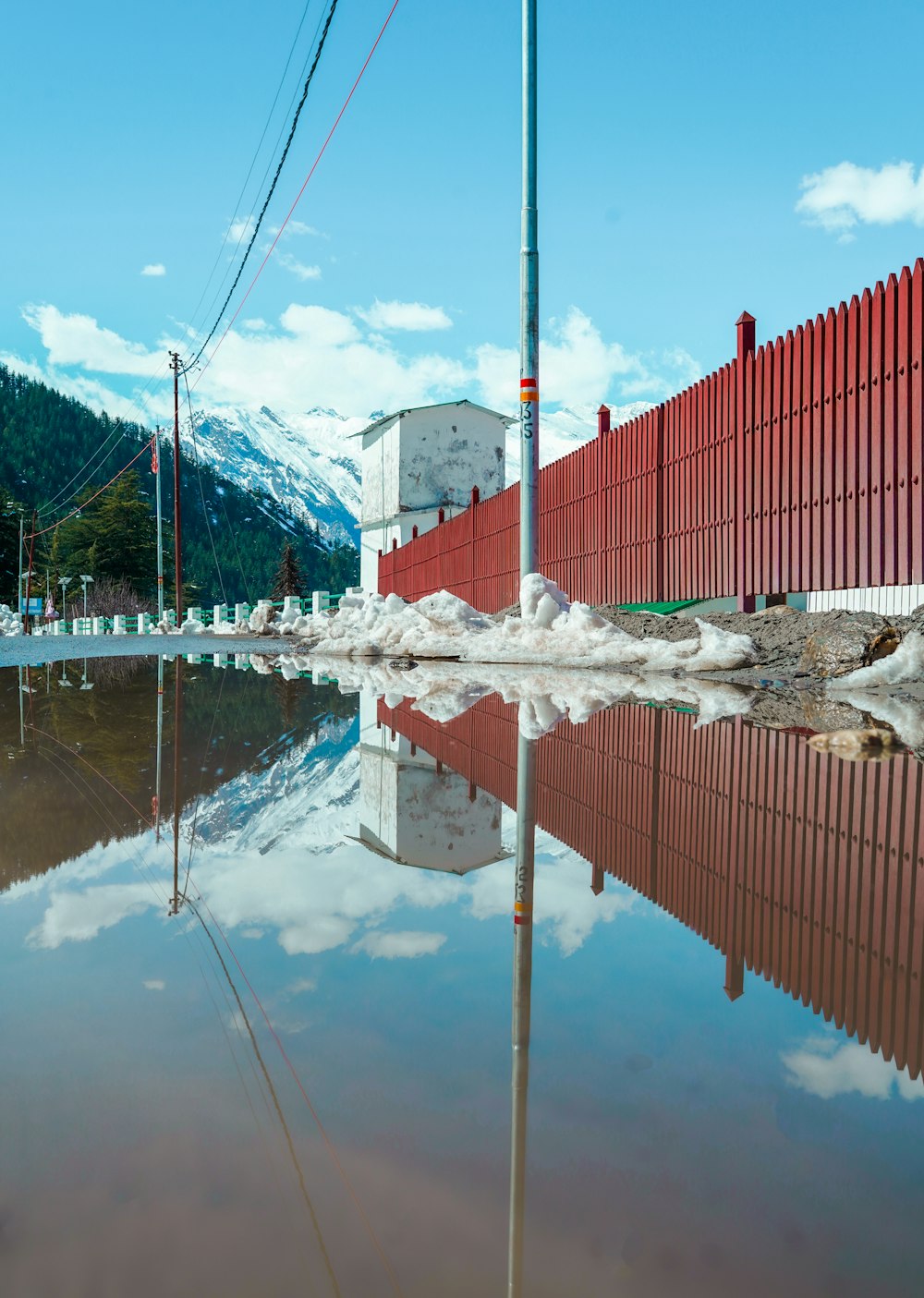 a red fence sitting next to a body of water