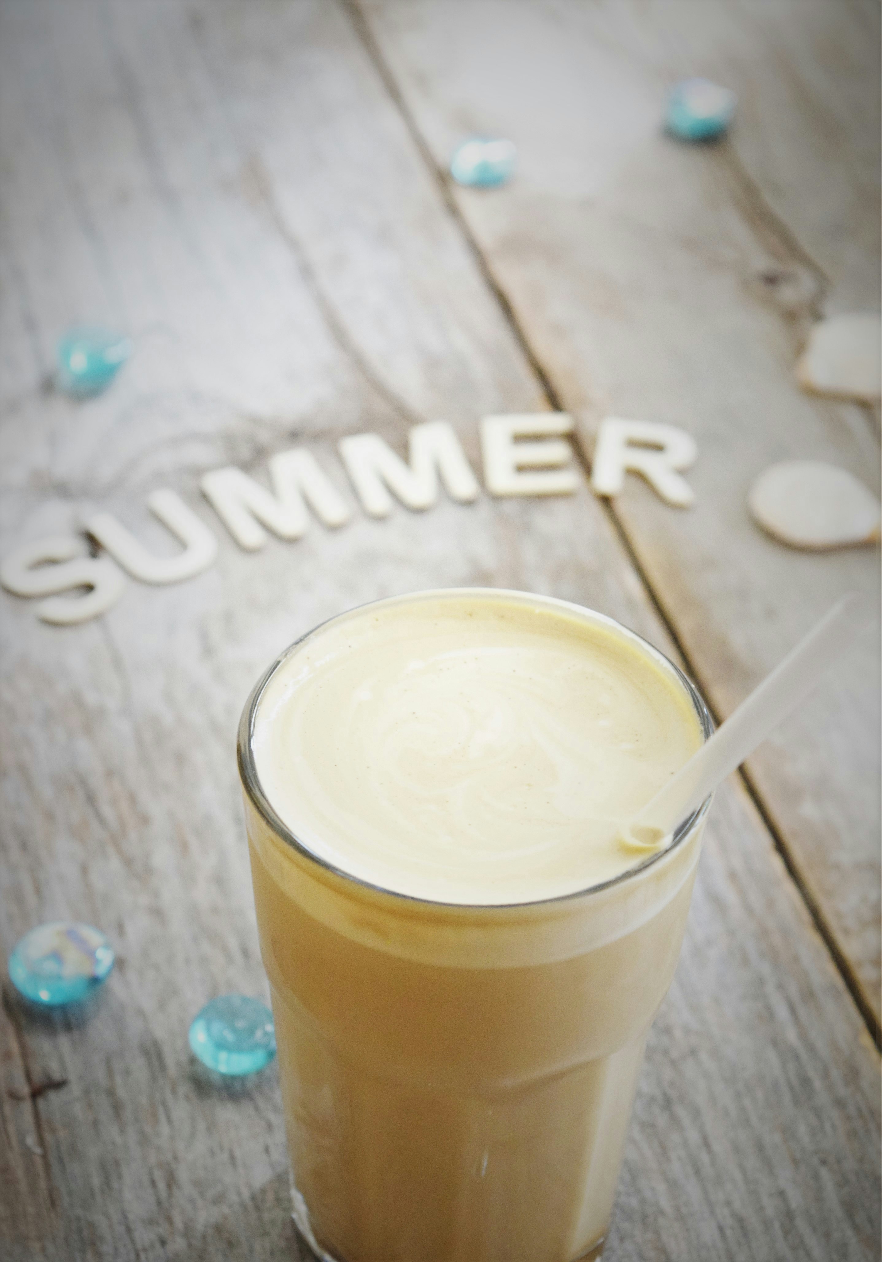 a glass of drink sitting on top of a wooden table