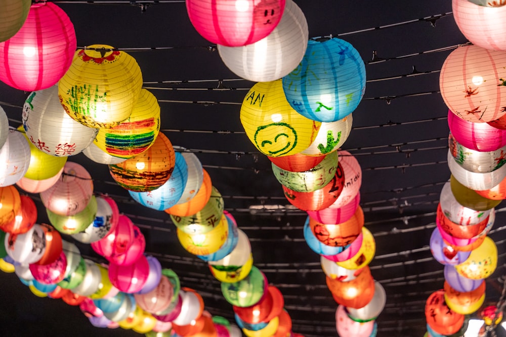 a bunch of colorful paper lanterns hanging from a ceiling