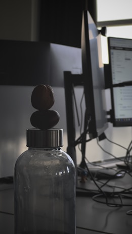 Synaptgen bottle placed on a wooden desk next to a notebook and glasses, suggesting productivity.