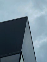 Roofing project featuring sharp lines and dark shingles complementing the modern design.