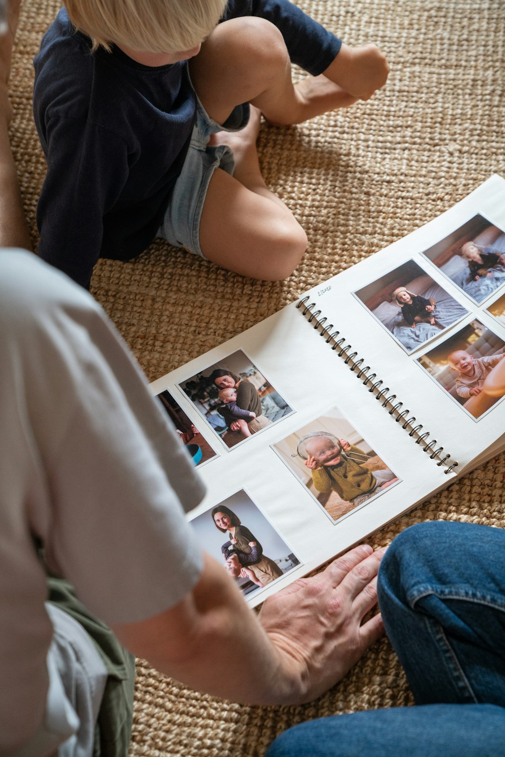 a young boy sitting on the floor reading a book