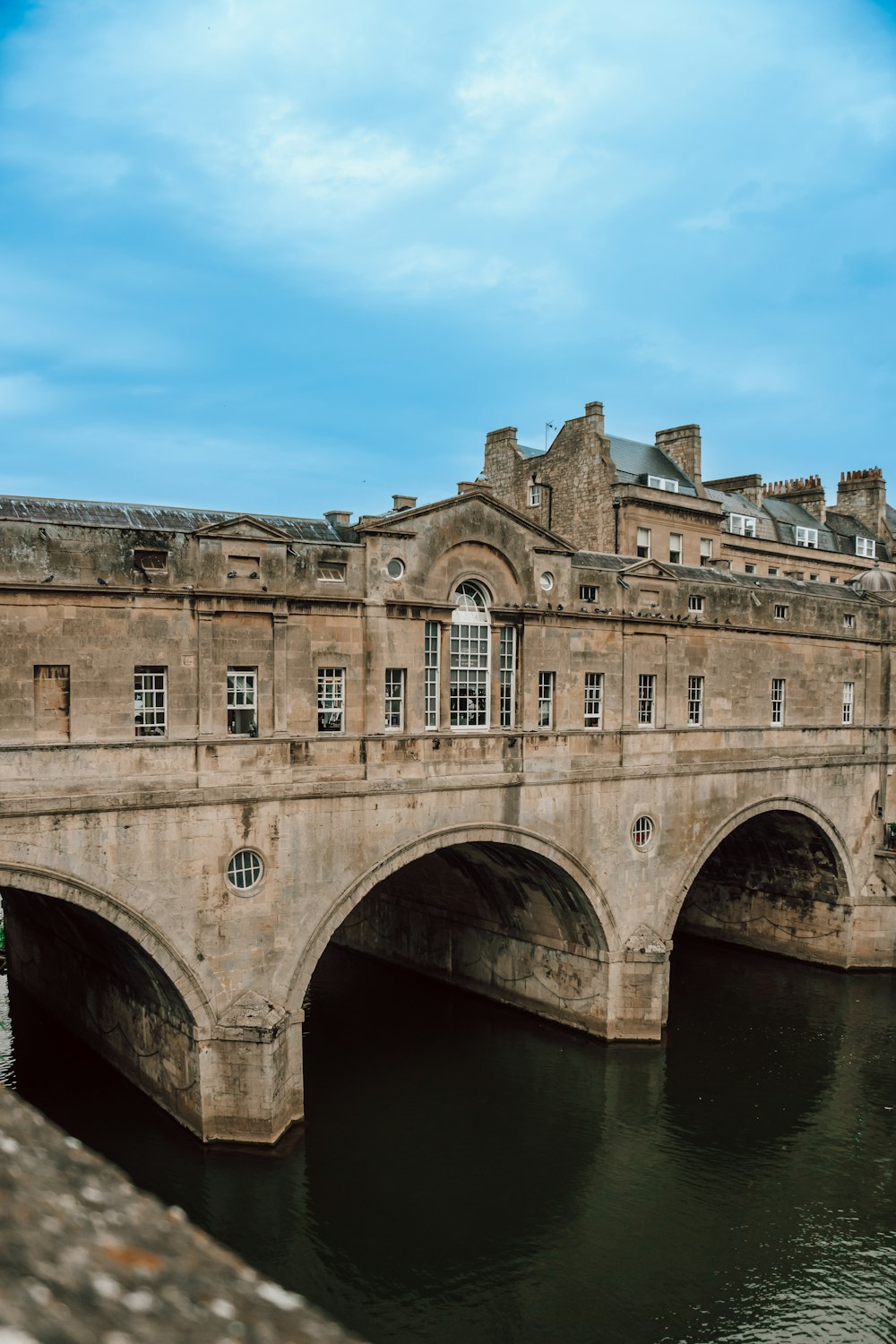 a bridge over a body of water with a building in the background